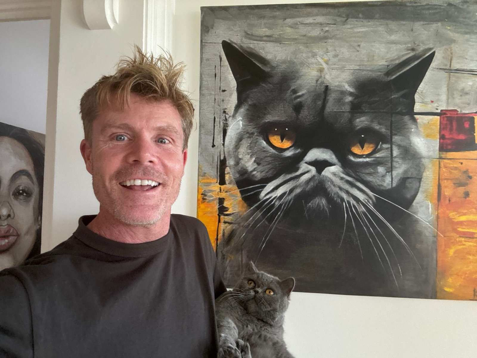 Keny with his cat beside her portrait