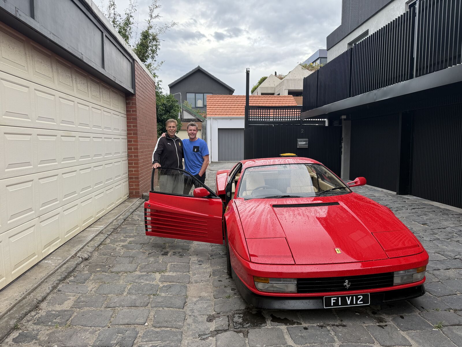 Lee Powell and his neighbour Roy beside a red Ferrari Testarossa in a Melbourne laneway