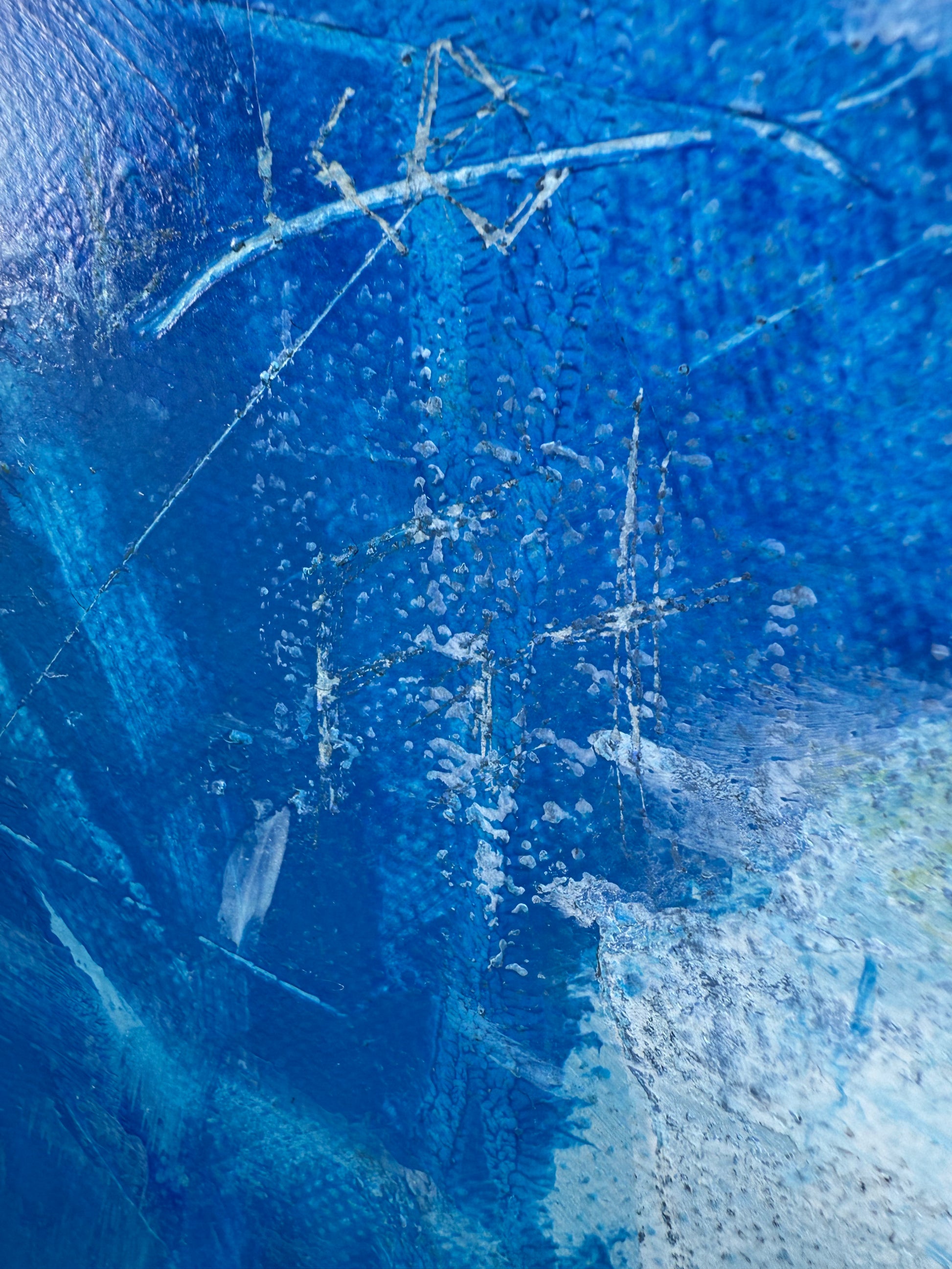 Close-up of a blue textured surface with white lines and patterns